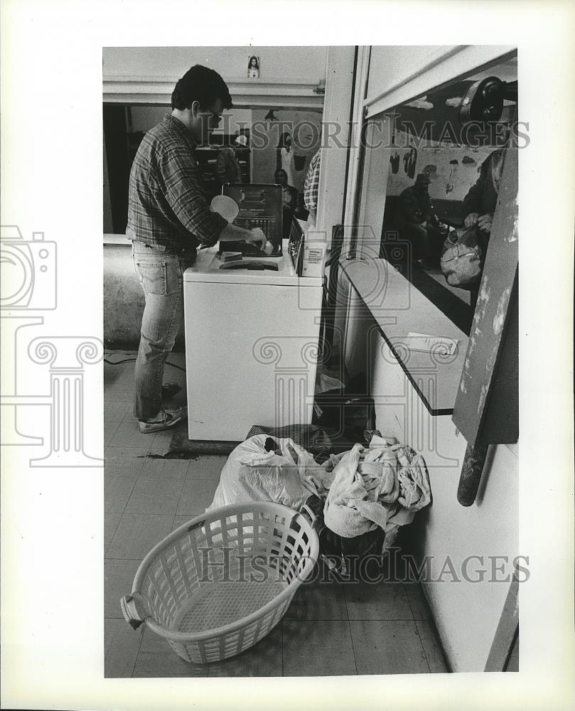 1984 Press Photo A man doing his laundry on home appliance, the washing ...
